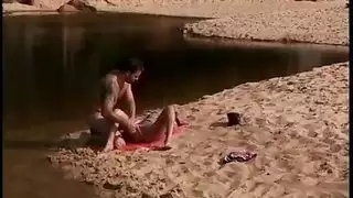 لعق الرمال قبالة مهبل امرأة سمراء شابة على الشاطئ الساخن